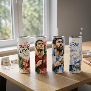 May include: Four cylindrical tumblers with straws featuring soccer-themed graphics. Two tumblers display portraits of soccer players in red and blue jerseys, while the others feature text including "Portugal Legend" and "The Maestro Born for Greatness."