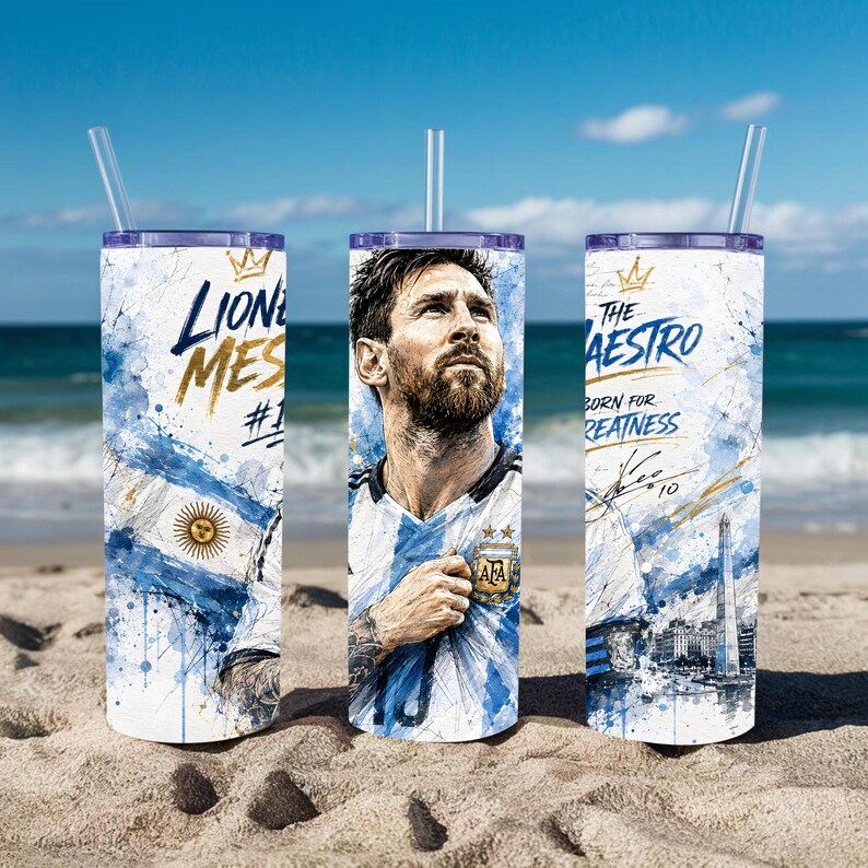 May include: A cylindrical tumbler with a clear straw featuring a graphic of Lionel Messi in an Argentina jersey, blue and white watercolor splashes, the text "Lionel Messi #10", "The Maestro", "Born for Greatness", and a signature with the number 10.
