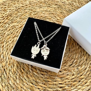 Embrace the duality of friendship with our unique necklace set, made from shimmering silver stainless steel. One pendant is forged into a lively flame, and the other into a gentle wave, representing the beautiful blend of different spirits.