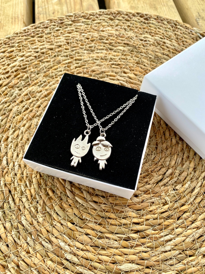 Embrace the duality of friendship with our unique necklace set, made from shimmering silver stainless steel. One pendant is forged into a lively flame, and the other into a gentle wave, representing the beautiful blend of different spirits.