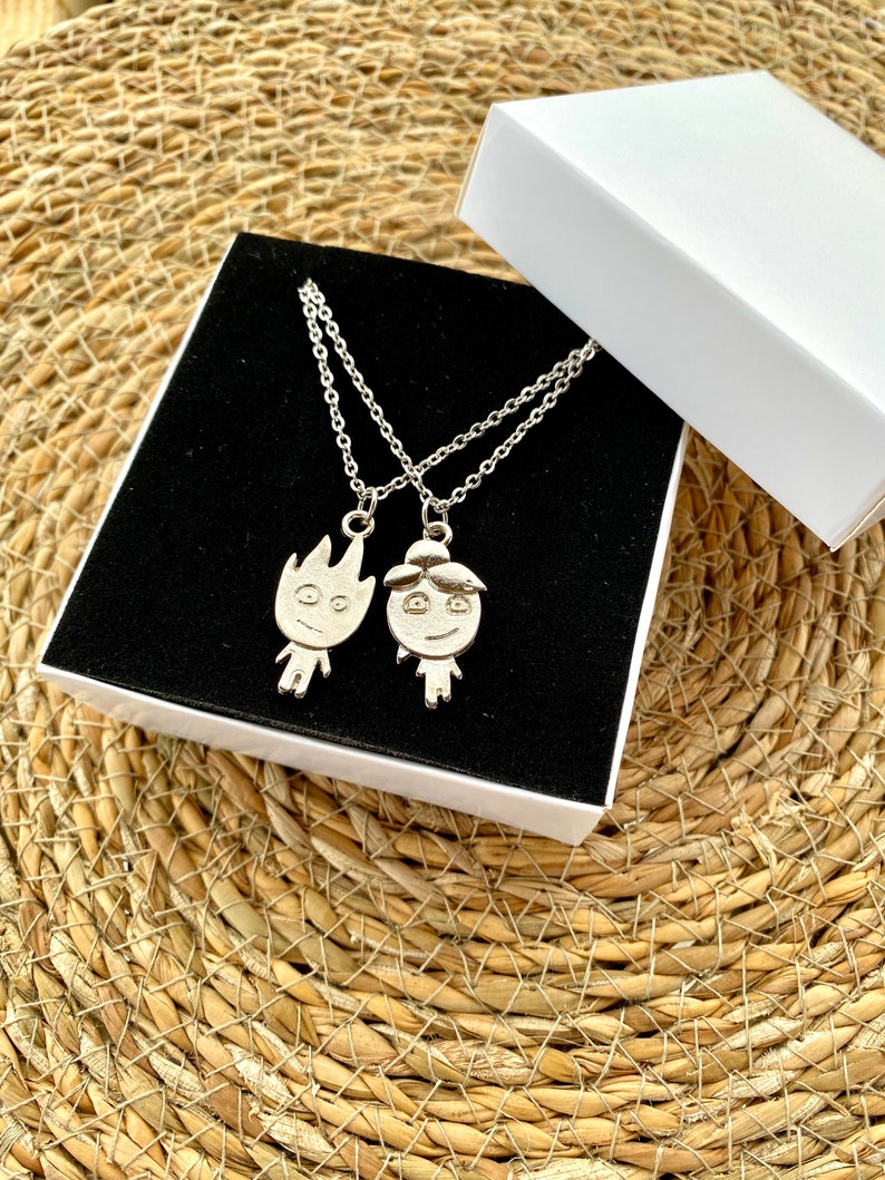 Discover the essence of companionship with our Friendship Necklace. Meticulously crafted in silver stainless steel, the set pairs the vigor of a fire-shaped pendant with the tranquility of a water-formed counterpart.