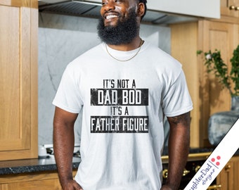 May include: White t-shirt with black text that reads "It's not a Dad Bod It's a Father Figure".