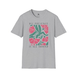 High-quality soft-style t-shirt made with ethically grown cotton. Beautiful floral graphic with a stylish font that says His presence is all around. Color sports grey.