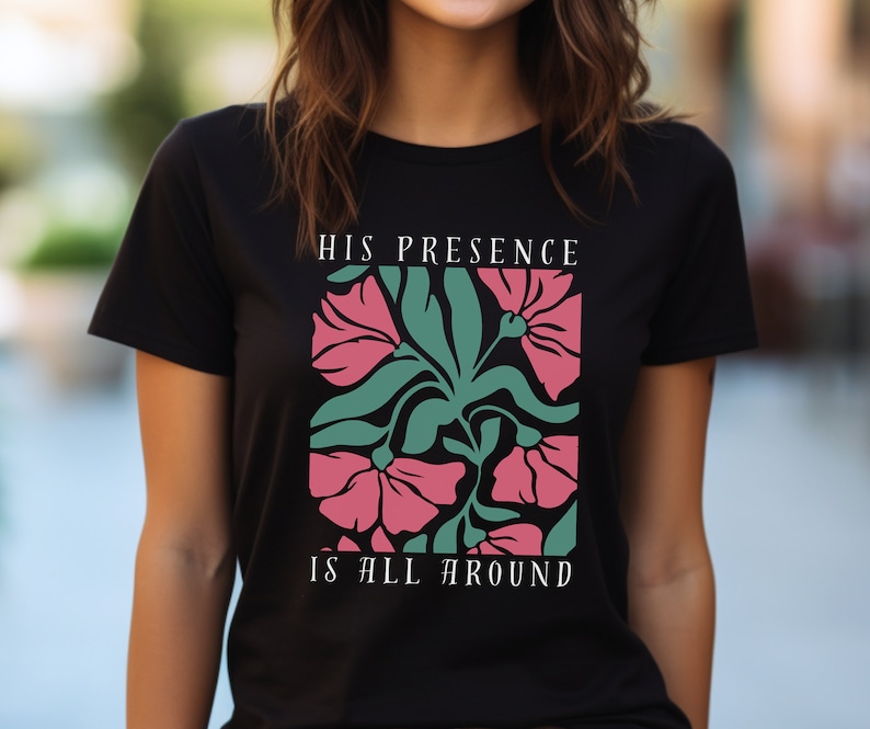 High-quality soft-style t-shirt made with ethically grown cotton. Beautiful floral graphic with a stylish font that says His presence is all around. Available in various colors. Female model wears black.