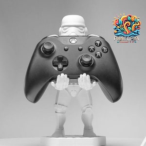 May include: A white 3D printed figurine of a Star Wars Stormtrooper holding a black Xbox controller.