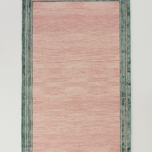 May include: Rectangular rug with a pink center and a teal green border. The rug has a textured appearance, with the pink area showing horizontal lines. The border is a darker teal green, with a fringe along the edge.