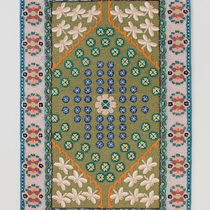 May include: A rectangular rug with a green center featuring white floral and blue accents. The rug has a pink and teal border with floral patterns. The rug's dimensions are approximately 24 x 36 inches.