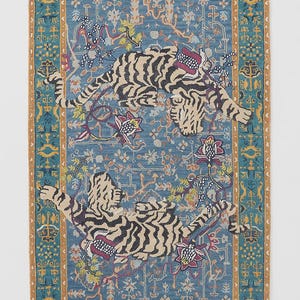 Puede incluir: Una alfombra rectangular con fondo azul y borde detallado. Dos tigres con rayas negras y detalles florales adornan la alfombra. La alfombra tiene un patr&oacute;n detallado y un borde marr&oacute;n.