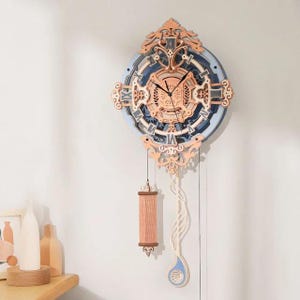 May include: A wooden clock with a blue and white face and intricate carvings. The clock has a pendulum and a weight that hangs from the bottom. The clock is a decorative piece for a home.