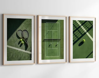 May include: Set of three framed prints featuring tennis court scenes. One print shows tennis rackets and balls, another an overhead view of players, and the third a tennis ball and court lines. The frames have a light wood finish.