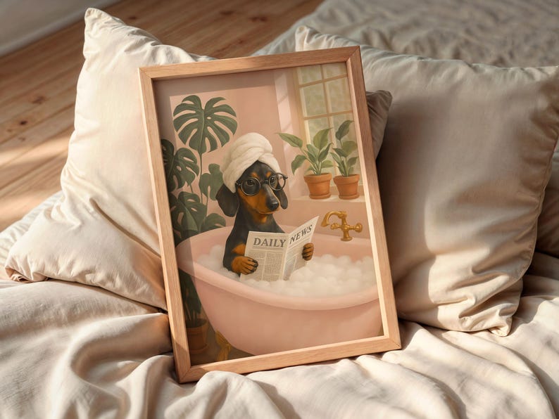 May include: A framed print depicts a dachshund in a bathtub, wearing a towel and glasses, reading a newspaper labeled "DAILY NEWS." The artwork has a soft, pastel color palette, with plants and a window in the background.
