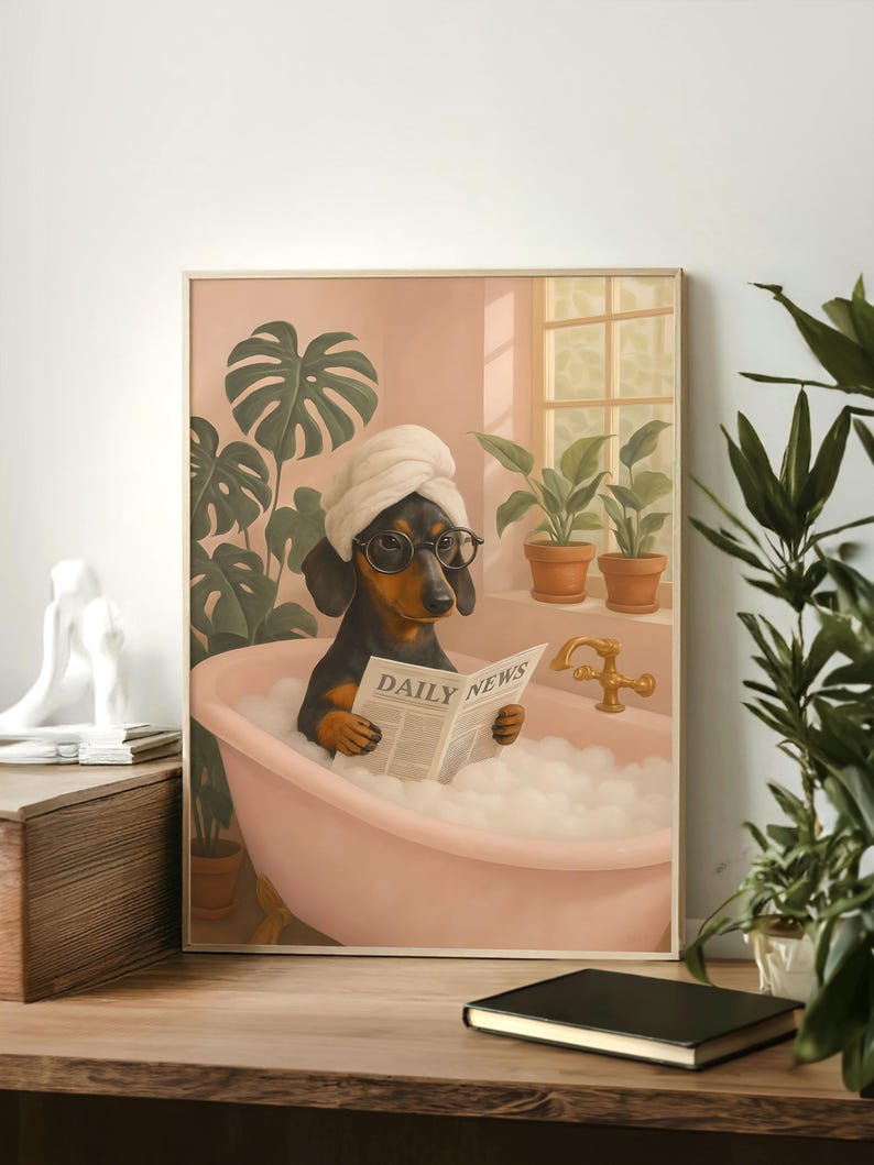 May include: A framed print depicts a dachshund in a bubble bath, wearing a towel and glasses, reading a newspaper with "DAILY NEWS" printed on it. The dog is in a pink tub, with plants and a window in the background. The print has a light brown frame.