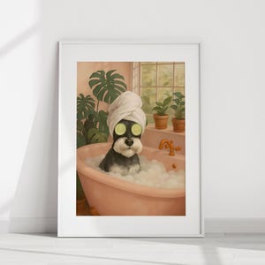 Könnte beinhalten: Gerahmter Druck eines Hundes in einer Badewanne. Der schwarz-weiße Hund trägt ein weißes Handtuch auf dem Kopf und Gurkenscheiben über den Augen. Der Hund befindet sich in einer rosa Badewanne voller Blasen. Grüne Pflanzen und ein Fenster sind im Hintergrund zu sehen.