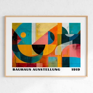 Peut inclure: Une impression d'art rectangulaire encadrée présentant une composition géométrique abstraite avec des formes superposées en bleu sarcelle, orange, jaune, rose et noir. Le texte BAUHAUS AUSSTELLUNG 1919 est imprimé en noir en bas de l'affiche.