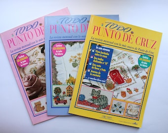 May include: Three magazines with yellow, blue, and pink covers. Each magazine features the title "TODO PUNTO DE CRUZ" and "La revista mensual con lo más nuevo de Punto de Cruz". The covers feature colorful embroidery designs.