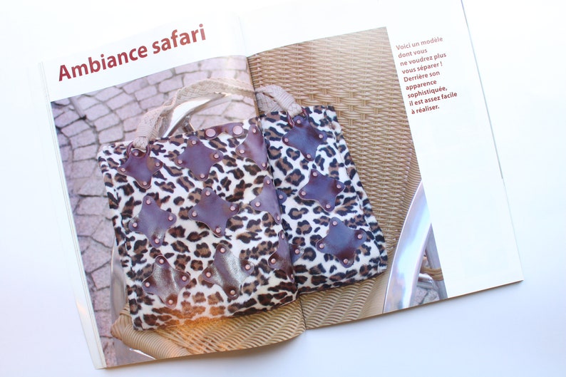 May include: Two leopard print tote bags with brown leather accents and metal studs. The bags are sitting on a wicker chair.
