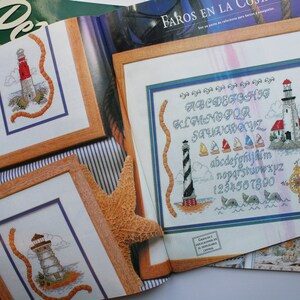May include: A magazine page with three cross-stitch patterns featuring lighthouses and nautical themes. The patterns include an alphabet, numbers, and a lighthouse with a rope design. The magazine page is titled "Faros en la Costa".