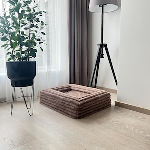 May include: A brown rectangular pet bed with a plush, quilted surface. The bed is made of soft, comfortable material and is perfect for a small dog or cat.