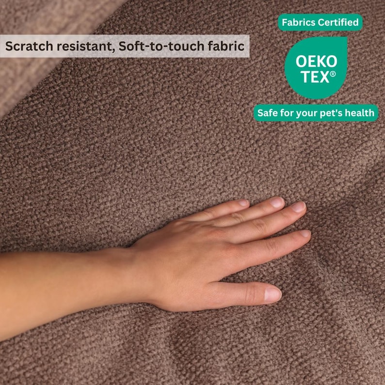 May include: Close-up of a brown, textured fabric. The fabric is labeled as scratch-resistant and soft-to-touch. The image also includes a "Fabrics Certified" label with the OEKO-TEX logo, indicating it's safe for pets.