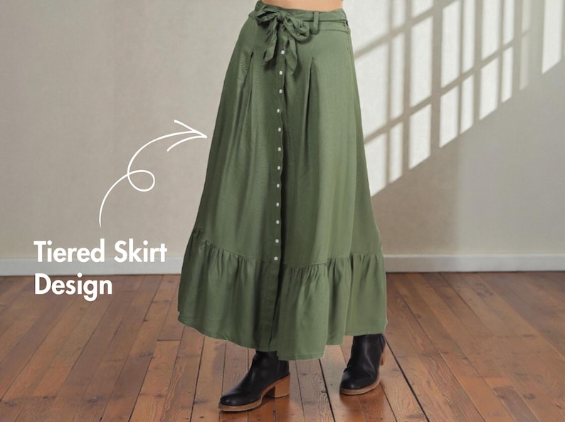 Op de afbeelding: Olijfgroene rok met lagen, een knoopsluiting en een strik in de taille. De rok heeft een geplooid zoom en wordt gecombineerd met zwarte enkellaarsjes. De tekst "Tiered Skirt Design" is zichtbaar.