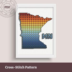 May include: A framed cross-stitch pattern of the state of Minnesota, filled with a gradient of colors from red-orange to blue. The letters "MN" are in a blue cross-stitch style. The words "Cross-Stitch Pattern" are at the bottom.