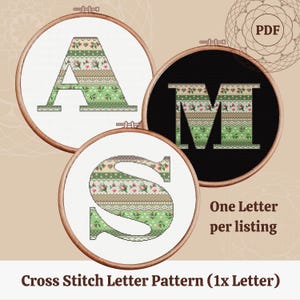 May include: Three cross-stitch letter patterns in embroidery hoops. The letters A, M, and S are displayed with a green and floral design. The text "One Letter per listing" and "Cross Stitch Letter Pattern (1x Letter)" are also visible.