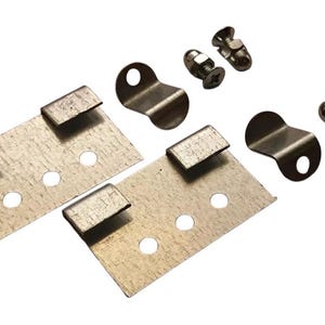 May include: A hardware kit featuring two rectangular metal plates, each with three holes and two bent tabs. Also included are two curved metal brackets and four screws with nuts. The hardware is silver in colour.