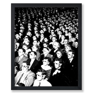 May include: Black and white framed print of a vintage movie theater audience. The crowd is wearing 3D glasses, creating a retro aesthetic. The image is a high-contrast, black and white photograph.