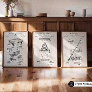 May include: Three framed prints featuring vintage billiard diagrams. The prints, in wooden frames, depict a billiard table, pool ball frame, and billiard cue. The text "Frame Not Included" is visible in the lower right corner. The prints are displayed on a wooden surface.