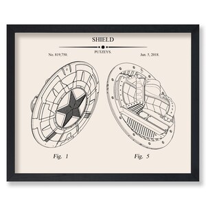 May include: Black framed print featuring a detailed technical drawing of a shield. The drawing shows two views of the shield, one with a star in the center. Text at the top reads "SHIELD" and "PUTZEYS". Includes the date "Jun. 5, 2018."