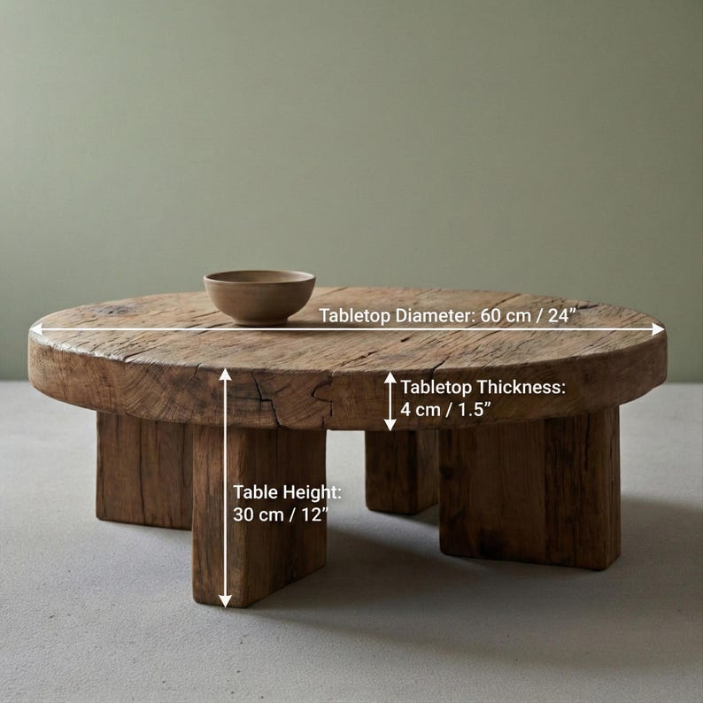 May include: A rustic, round coffee table made of reclaimed wood. The tabletop diameter is 24 inches, with a thickness of 1.5 inches. The table stands 12 inches tall. A small, brown bowl sits on the table. The table has a natural, weathered appearance.