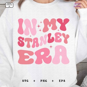 May include: White sweatshirt with pink and red text that reads "In My Stanley Era".