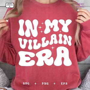 May include: A red sweatshirt with the text "In My Villain Era" in white, retro-style lettering. The text is surrounded by small white stars.