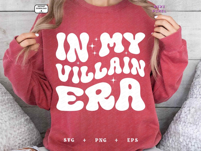 May include: A red sweatshirt with the text "In My Villain Era" in white, retro-style lettering. The text is surrounded by small white stars.