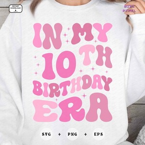 以下が含まれることがあります： ピンクの色合いで「IN MY 10TH BIRTHDAY ERA」というテキストがプリントされた白いスウェットシャツ。デザインには星のアクセントとSVG、PNG、EPSのファイルタイプが含まれています。カジュアルなスタイルのスウェットシャツです。