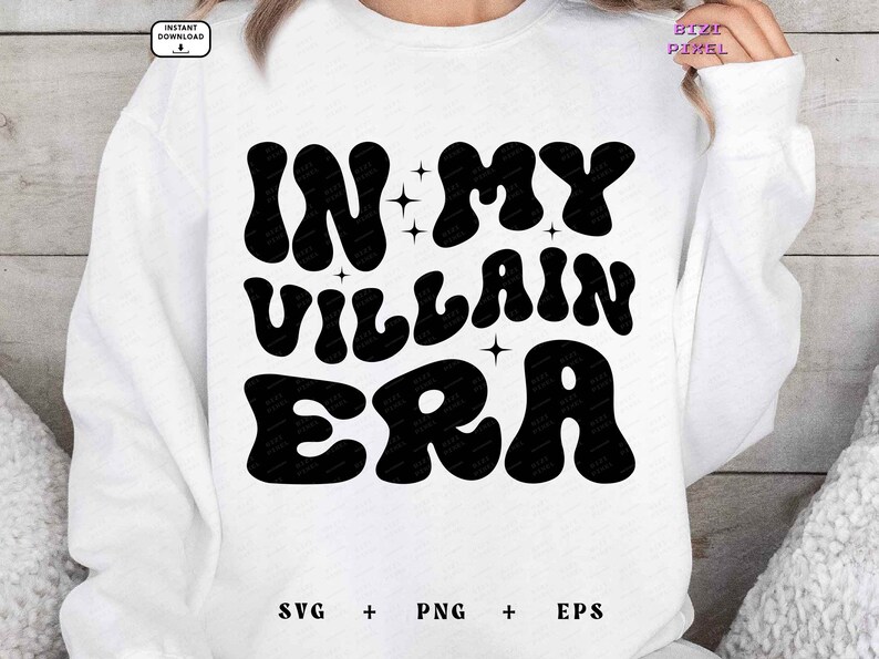May include: White sweatshirt with black text that reads "In My Villain Era" in a retro font. The text is surrounded by small stars.