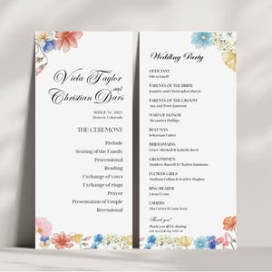 May include: Wedding ceremony program with floral accents in shades of pink, blue, and green. The program lists the order of events for the ceremony, including the prelude, seating of the family, processional, reading, exchange of vows, exchange of rings, prayer, presentation of couple, and recessional. The program also includes a list of the wedding party members and their roles.