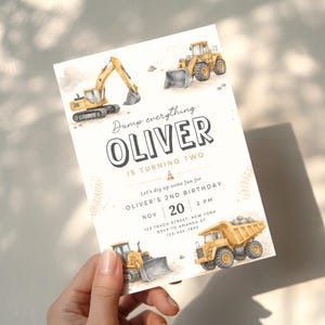 Puede incluir: Una tarjeta de invitación de cumpleaños rectangular con ilustraciones en acuarela de vehículos de construcción amarillos, incluyendo una excavadora, una cargadora y un camión volquete. El texto dice: Dump everything OLIVER IS TURNING TWO, Let's dig up some fun for OLIVER'S 2ND BIRTHDAY, NOV 20 2 PM, 123 TRUCK STREET, NEW YORK, RSVP TO AMANDA AT 123-456-7890.