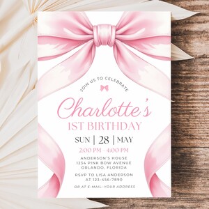 Puede incluir: Una invitaci&oacute;n de cumplea&ntilde;os rosa y blanca con un gran lazo de acuarela y cintas. El texto dice "Charlotte's 1st Birthday" con los detalles del evento. La invitaci&oacute;n est&aacute; sobre un fondo de madera.