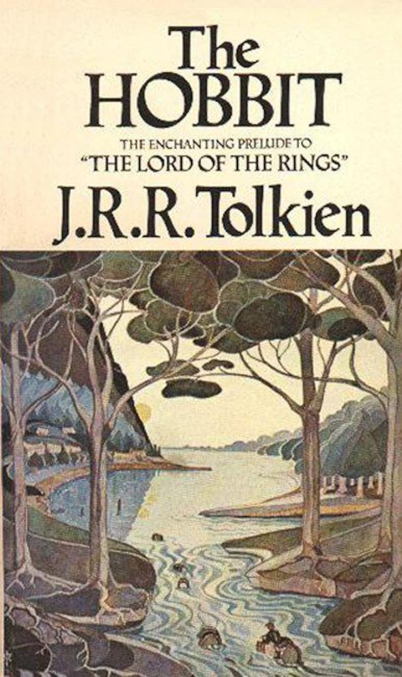 Puede incluir: La portada del libro "El Hobbit" de J.R.R. Tolkien. La portada presenta una pintura de paisaje de un r&iacute;o serpenteando a trav&eacute;s de un bosque con dos &aacute;rboles en primer plano.