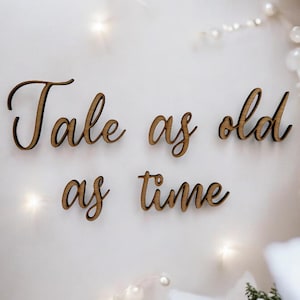 Puede incluir: Letrero de madera con la frase "Tale as old as time" en letras cursivas.