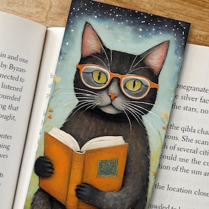 May include: A black cat wearing glasses sits and reads a book with an orange cover. The cat is surrounded by a blue and green background with white stars.