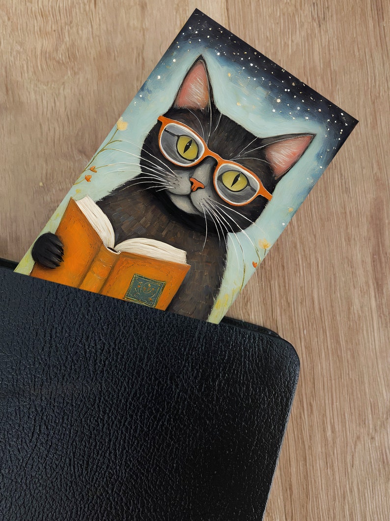 May include: A black cat wearing orange glasses is reading a book. The cat is sitting in front of a blue background with white stars. The book is orange and has a gold design on the cover.