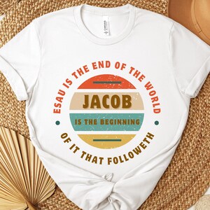 May include: White t-shirt with a vintage-style circular graphic that reads "ESAU IS THE END OF THE WORLD JACOB IS THE BEGINNING OF IT THAT FOLLOWETH".