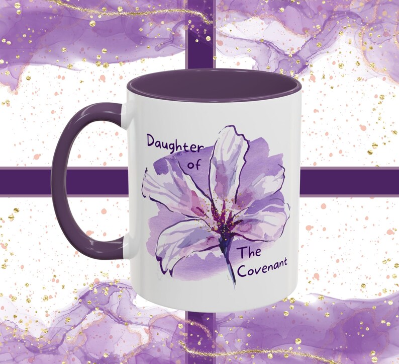 May include: White ceramic mug with a purple rim and handle. The mug features a watercolor illustration of a purple flower with the text "Daughter of The Covenant".