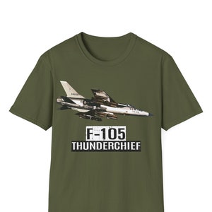May include: A green t-shirt with a camouflage F-105 Thunderchief fighter jet graphic. The text "F-105 Thunderchief" is printed in black below the jet.