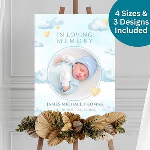 May include: A memorial sign with a baby's image, clouds, and hearts. Text reads "In Loving Memory" and includes the name "James Michael Thomas" and dates. The sign is on an easel and decorated with dried flowers. The text "4 Sizes & 3 Designs Included" is also present.