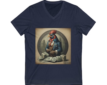 Puede incluir: Una camiseta de cuello en V azul marino con un gráfico de un gallo con traje y sosteniendo dinero. El gallo está rodeado de un diseño circular con el texto "In The Face Of Adversity".
