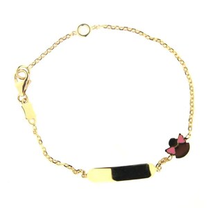 Puede incluir: Un brazalete de cadena de oro con un pequeño dije de esmalte rosa y negro y una placa de nombre en blanco.