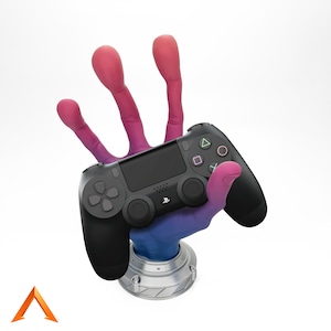 Könnte beinhalten: Ein schwarzer PlayStation 4-Controller wird von einer Hand mit pinken und blauen Fingern gehalten. Der Controller ruht auf einem silbernen Sockel.
